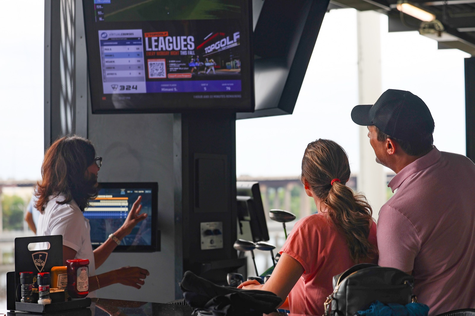 Spark golfers cheering at the league leaderboard at Topgolf
